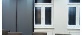 Czarne żaluzje i panele: kontrastowy styl, funkcjonalność i elegancja, nowoczesne podejście do aranżacji okna.
